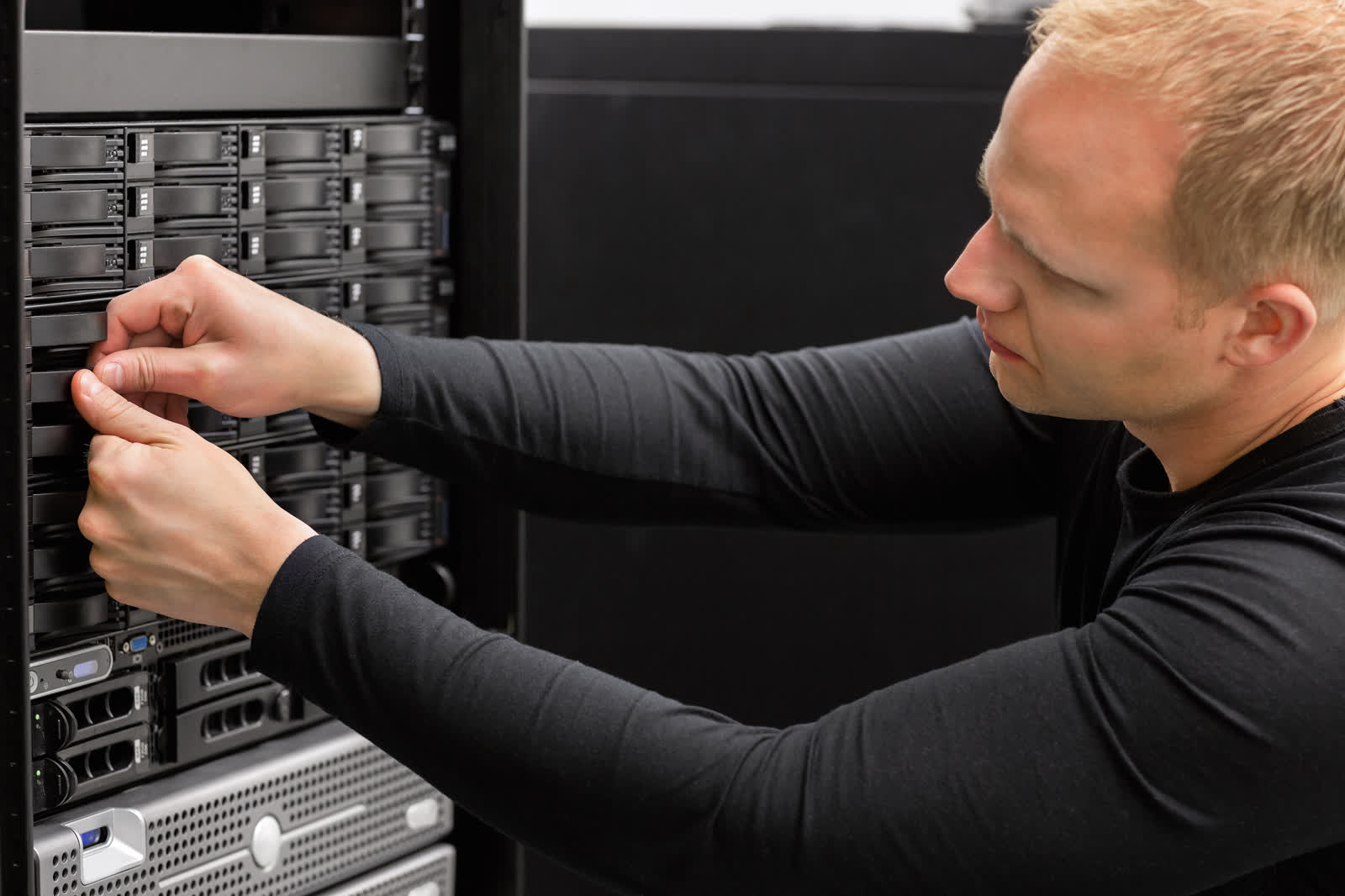 Techniker arbeitet am geöffneten Serverschrank im Rechenzentrum